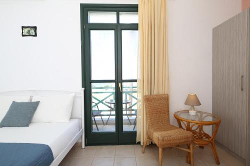 a bedroom with a bed and a table with a chair at Anastasia Apartments in Korissia