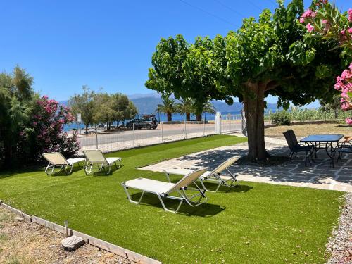 a group of chairs and a table and a tree at Nafpaktos PebBle Apartments in Marathias in Marathiás