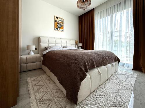 a bedroom with a large bed and a large window at Qoople Excellence apartments by the sea in Alanya