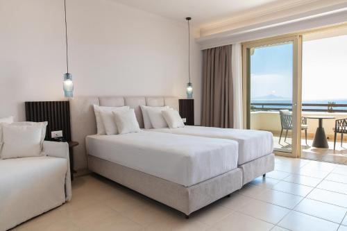 a hotel room with two beds and a balcony at Grand Blue Beach Hotel in Kardamaina