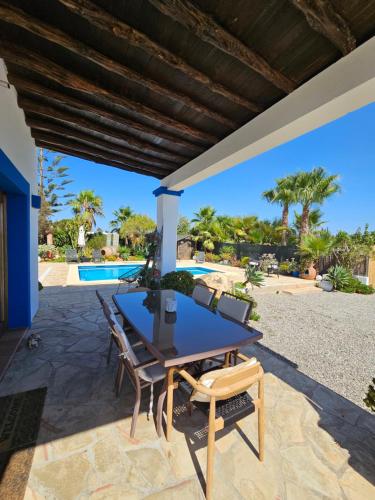 a table and chairs on a patio with a pool at Villa en Sa Caleta - CAN BLAU IBIZA in Ibiza Town