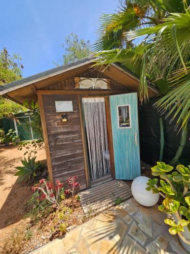 a small house with a wooden door in a yard at Villa en Sa Caleta - CAN BLAU IBIZA in Ibiza Town