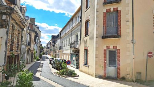 an alley with buildings and cars on a street at Apartment in Downtown in Châteaubriant