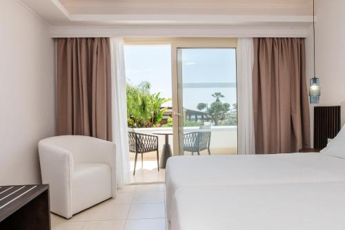 a hotel room with a bed and a view of the ocean at Grand Blue Beach Hotel in Kardamaina
