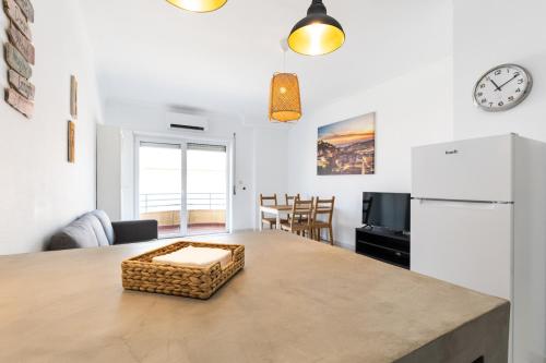 a kitchen and living room with a large table with a counter top at Hoso Apartments T1 in Costa da Caparica
