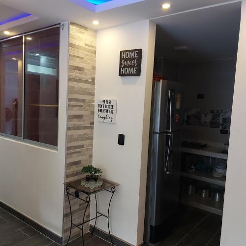 a room with a table and a refrigerator at Elegancia, Calor y Comodidad in Melgar