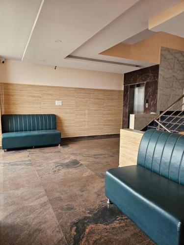 a waiting room with two blue leather couches at Golden Key Hotel in Bengaluru