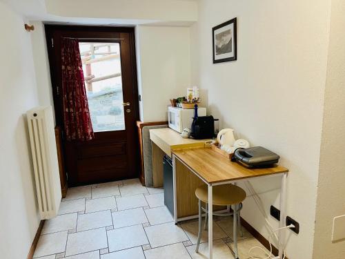 a small kitchen with a table and a microwave at Affittacamere Buenavista Guest House in Champoluc