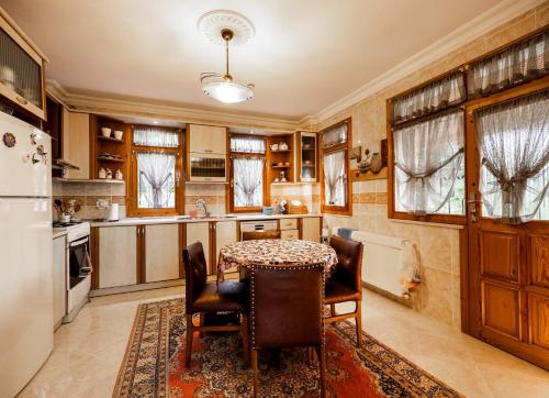 Una cocina con mesa y sillas y un refrigerador. en Doğa ile iç içe, en Çukurçayır