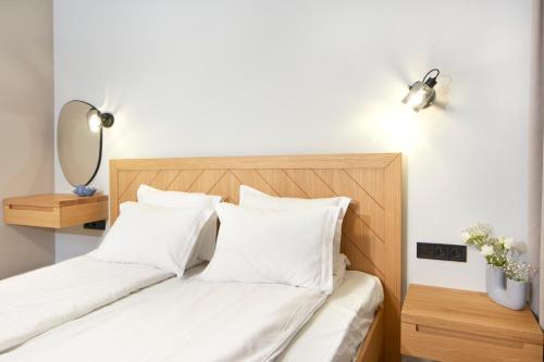 a bedroom with a bed with white sheets and white pillows at Семеен хотел НОА in Nesebar