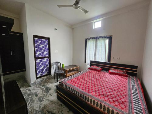 a bedroom with a bed and a chair and a window at Pandit Devki Nandan Dharamsala & Guest House in Deoghar