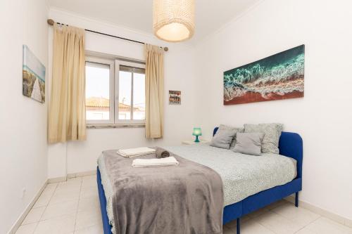 a bedroom with a bed and a window at Hoso Apartments T1 in Costa da Caparica