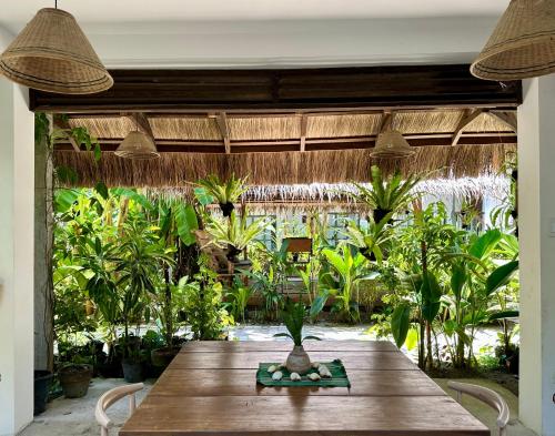 a dining room with a table and some plants at Alpas Siargao in General Luna