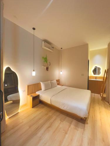 a bedroom with a large white bed and a tv at Dreamy Homestay Tam Đảo in Tam Ðảo