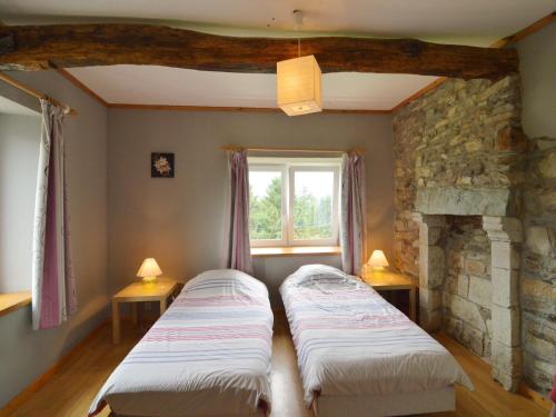 two beds in a room with a stone fireplace at Lovely house with much luxury and comfort in Waimes