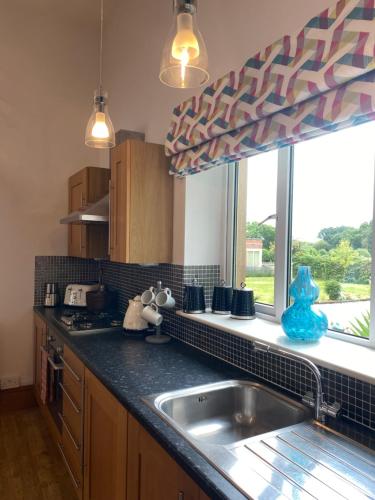 a kitchen with a sink and a window at 2 Bed Countryside Retreat in Dorset Includes a private Hot Tub and cosy wood burner in Horton