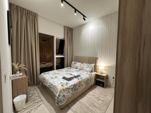 a small bedroom with a bed and a window at Cozy Golf & Lake View 1BR Apartment,Damac Hills 1 in Dubai