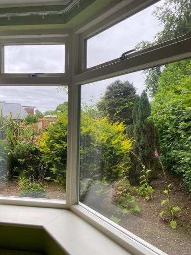 a window with a view of a garden at 2 Bed Countryside Retreat in Dorset Includes a private Hot Tub and cosy wood burner in Horton