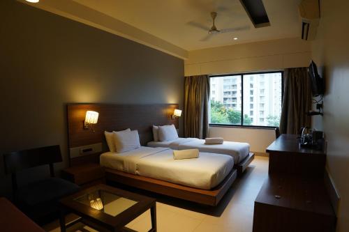 a hotel room with a bed and a window at Hotel Sadanand Regency - Newly Renovated in Pune