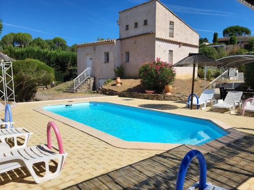 a swimming pool in front of a house at 15mn de Cannes, Villa la Soleiade , Gite ,Lodge , type T2, clim, piscine, parking au Lac de Saint-Cassien VAR in Montauroux