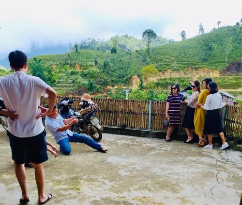 a group of people standing next to a fence at Bản Liền Trà hills homestay in Bắc Hà