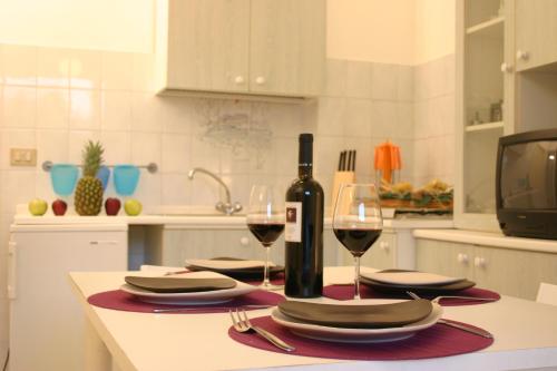 a table with a bottle of wine and two glasses at Guest House - La Sirena Salentina in Patù