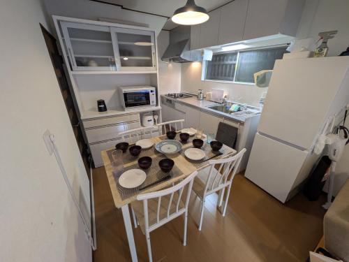 a kitchen with a table and chairs and a refrigerator at Villa Otsu by Kyoto ヴィラ大津 by 京都 6人泊 3BR 京都駅10分 大津駅徒歩5分 in Otsu