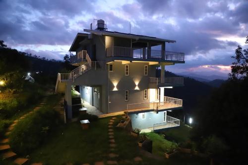 a building with a pool in front of it at The Blissful Trails 3BR Home 1 in Satkhol by Homeyhuts in Mukteswar