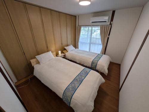 a small room with two beds and a window at Villa Otsu by Kyoto ヴィラ大津 by 京都 6人泊 3BR 京都駅10分 大津駅徒歩5分 in Otsu