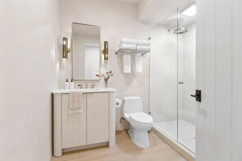 a white bathroom with a toilet and a shower at Casa Riviera - Boutique Suites in Downtown Santa Barbara in Santa Barbara