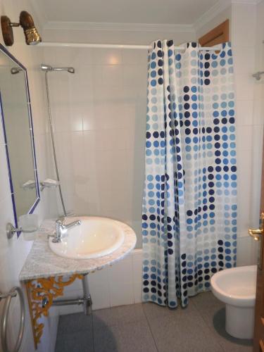 uma casa de banho com um lavatório e uma cortina de chuveiro em Hostal Miraflor de las Cadenas em Cuacos de Yuste