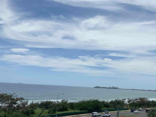 a view of the ocean with cars driving on a road at Meridian Alex Beach Apartments in Alexandra Headland