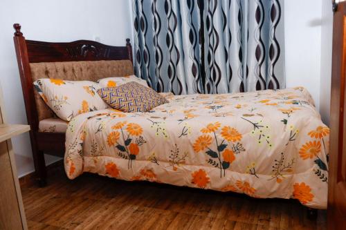 ein Bett mit einer Bettdecke und Kissen darauf in der Unterkunft Mirema Suite 1 in Nairobi