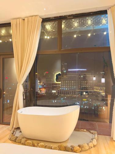 a bath tub in front of a window with a view of a city at Dreamy Homestay Tam Đảo in Tam Ðảo