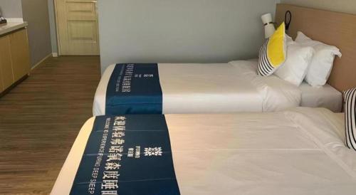 a hotel room with a bed withcriptions on it at Imin Hotel in Huadu