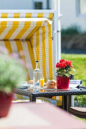 a table with a bottle of wine and flowers on it at Sylter Domizil in Wenningstedt