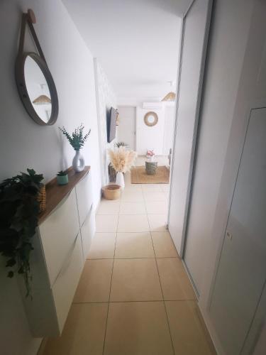 - un couloir doté de carrelage et d'un miroir dans l'établissement Appartement T2 à Porto-Vecchio, à Porto-Vecchio