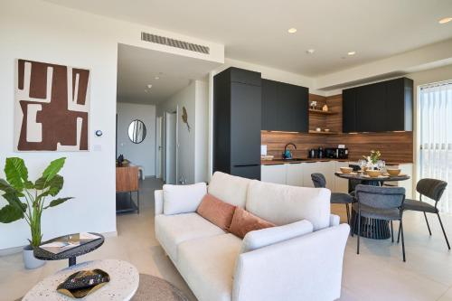 a living room with a white couch and a kitchen at Luxurious Level 26 Getaway in St. Julianʼs