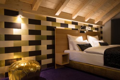 a bedroom with a bed with a checkerboard wall at Das Freiberg Romantikhotel in Oberstdorf