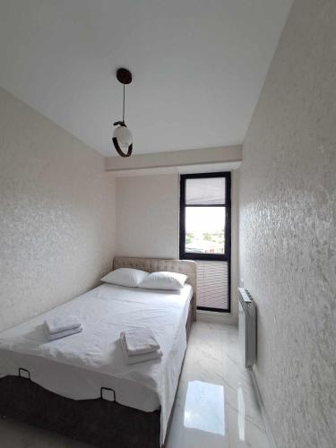 a bedroom with a large bed and a window at Gelati Loft Apartment in Kutaisi