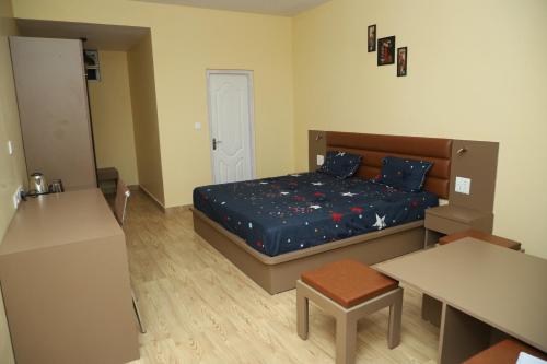 a small bedroom with a bed and a table at The Blissful Trails 3BR Home 1 in Satkhol by Homeyhuts in Mukteswar
