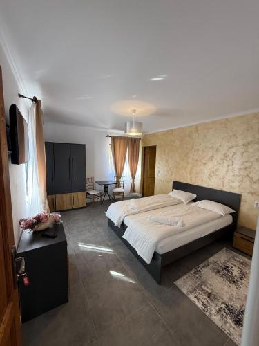 ein Schlafzimmer mit einem großen Bett und einem Tisch in der Unterkunft Casa Stauder in Seini