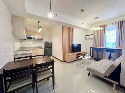 a living room with a dining table and a kitchen at Escarlett 1 Bedroom 15th Floor Cagayan de Oro in Pontud
