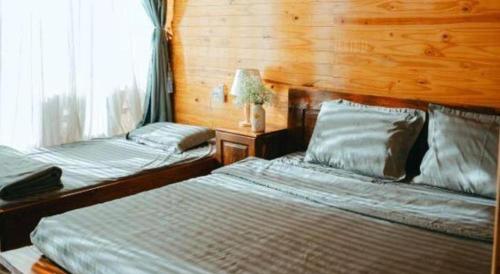 a bedroom with two beds and a window at Jun's Home in Buon Ma Thuot