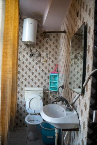 a small bathroom with a toilet and a sink at Ved Hotel & Restaurant in Agra