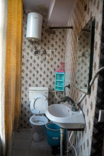a small bathroom with a toilet and a sink at Ved Hotel & Restaurant in Agra