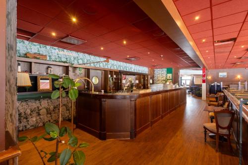 a restaurant with a counter and a bar at Injoy Classic Hotel Halmstad in Halmstad
