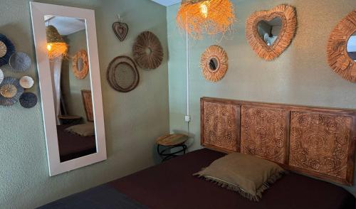 une chambre avec un lit, un miroir et des couronnes dans l'établissement Sète plage les quilles, à Sète