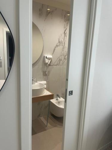 a bathroom with a sink and a mirror at Hera Rooms and Suites in Agrigento