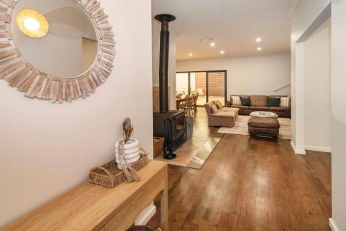 a living room with a fireplace and a mirror at Little Herring Ducted AC heating, Secure yard in Vasse